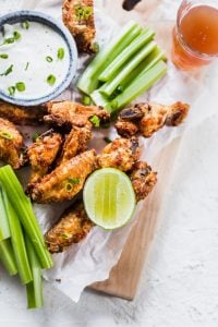 Extra Crispy Air Fryer Wings on board up close with ranch dressing and celery. lenaskitchenblog.com