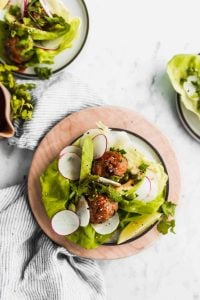 air fryer asian pork meatballs in lettuce cups with fresh vegetables and sesame ginger dressing