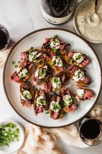 Steak crostini on a plate with balsamic glaze.