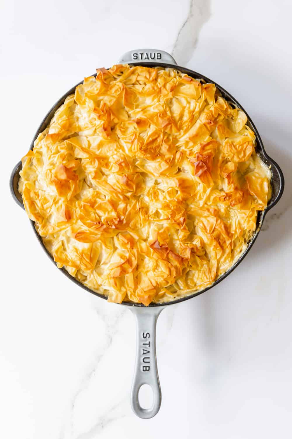 a phyllo-topped chicken pot pie in a large cast iron skillet.