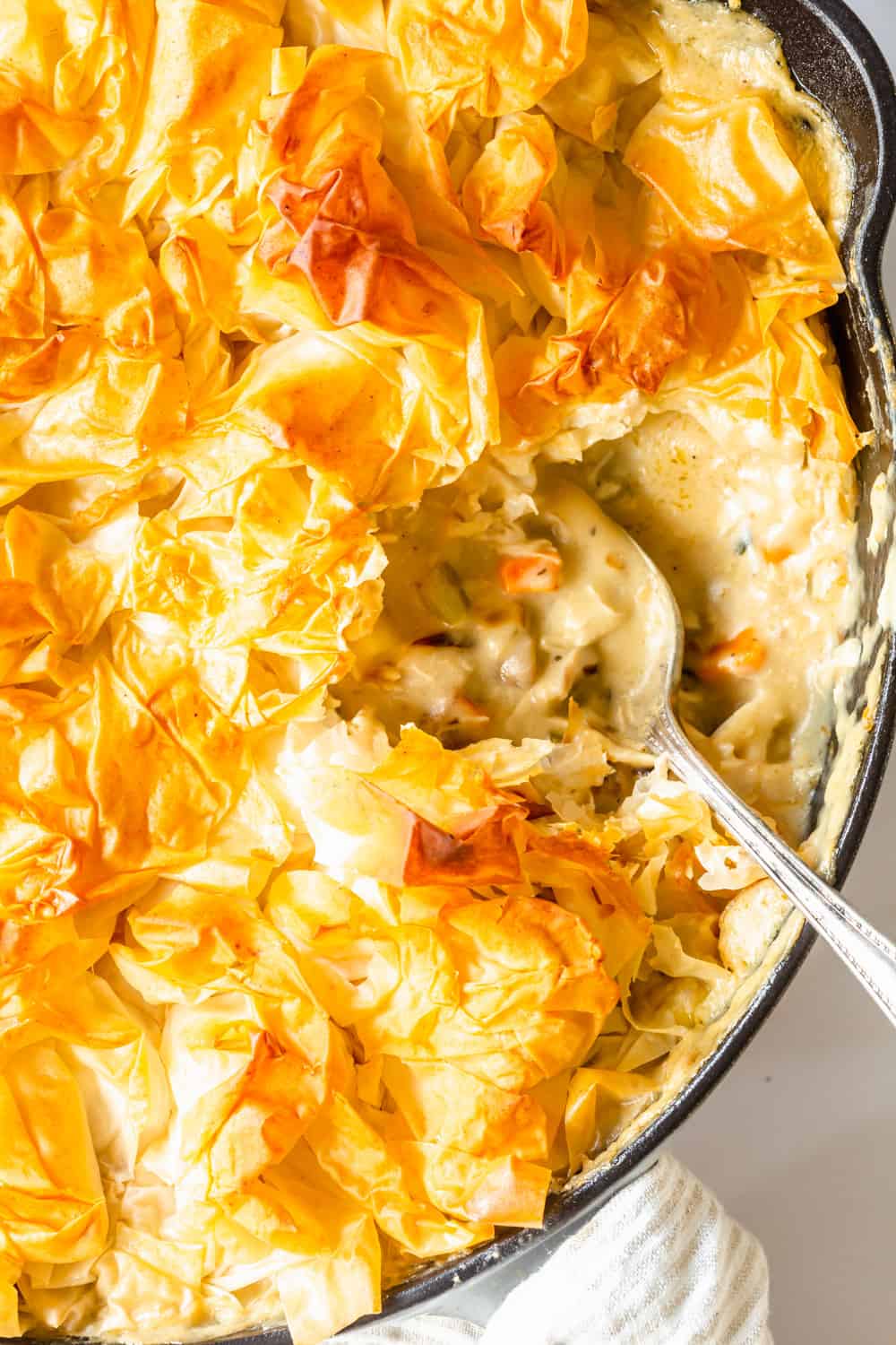 close up on a spoon taking a scoop out of a chicken mushroom pot pie.