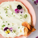 Chips dipping into a bowl of Brie.