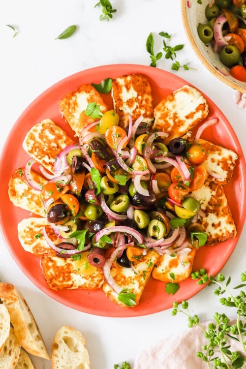 Fried halloumi and tomato salad on a plate.