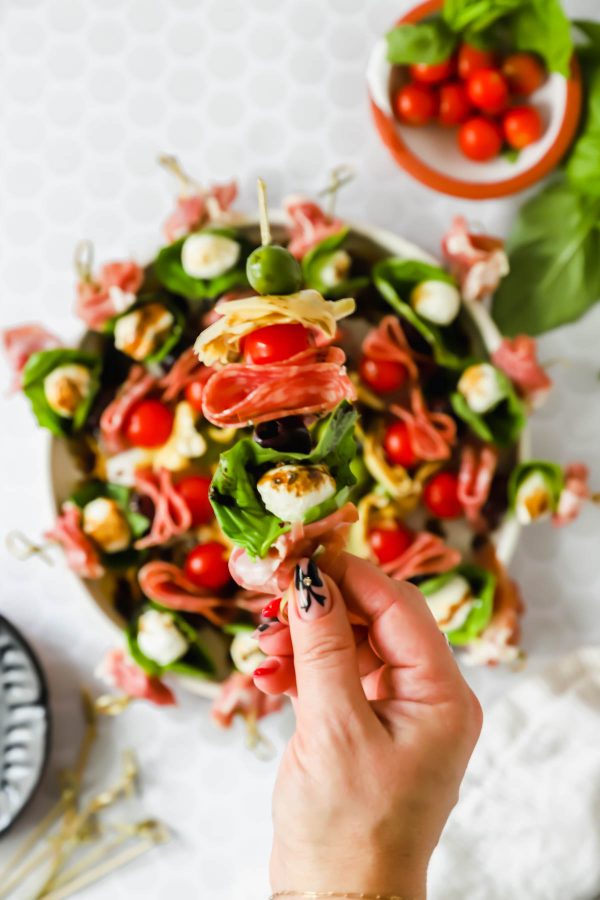 Hand holding a charcuterie skewer.
