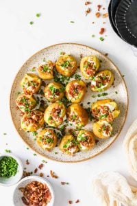 Baby potatoes with toppings on a platter.