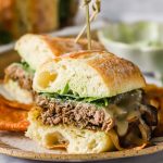 A steak sandwich on a plate.