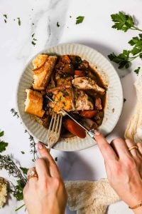 hands cutting coq au vin.