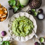 Overhead shot of easy artichoke dip with a slightly chunky yet creamy texture with visible arugula specks.