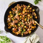 Overhead shot of skillet with homemade steak bites and potatoes.