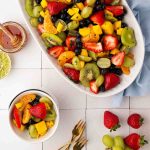 Overhead shot of honey lime fruit salad in a serving dish and small bowl.