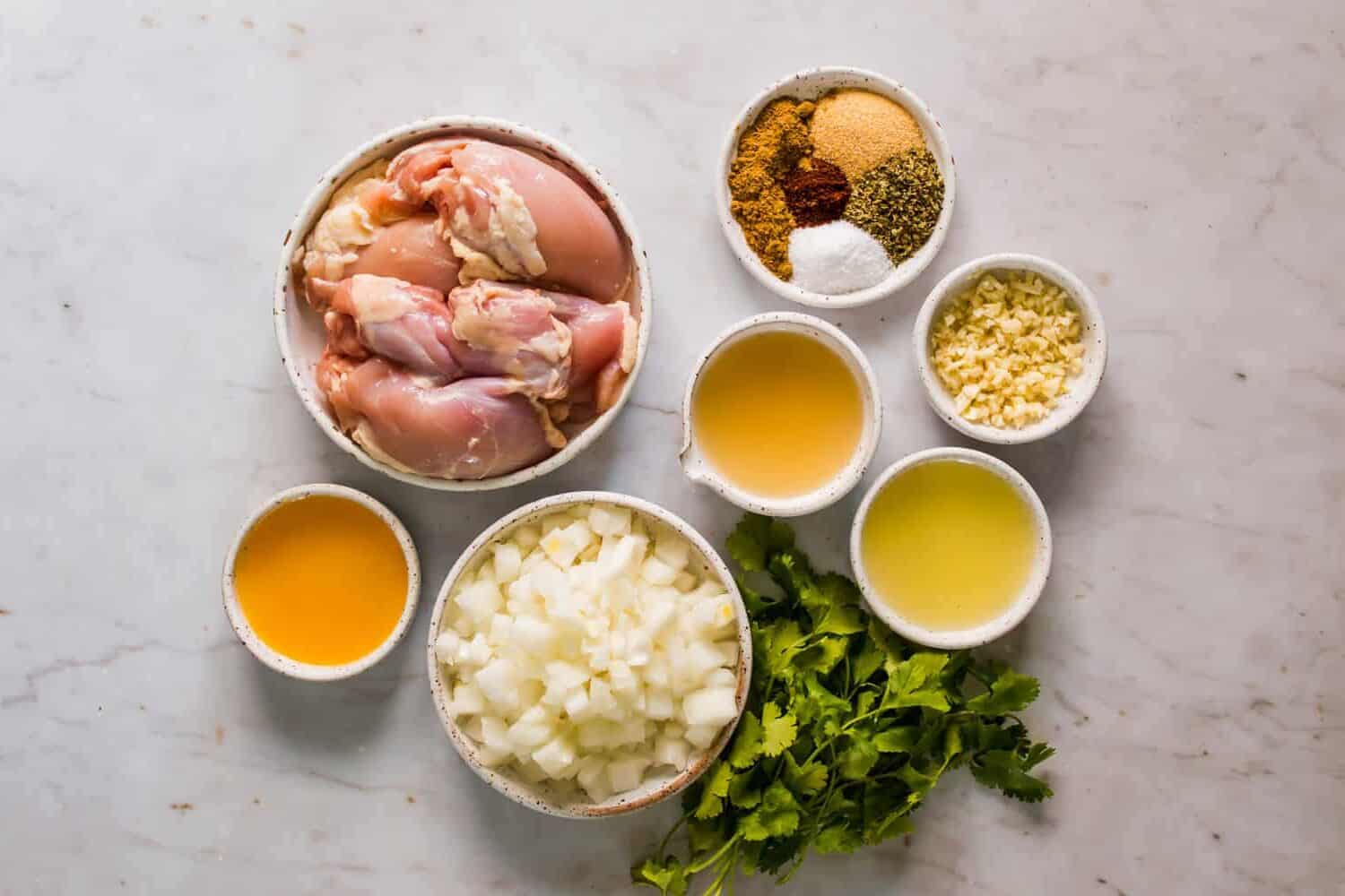 small white bowls filled with broth, juice, raw chicken, onions, and seasonings