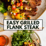 Grilled flank steak topped with colorful corn and tomato salsa, served with arugula salad on a plate. Text overlay reads, “Easy Grilled Flank Steak.”.